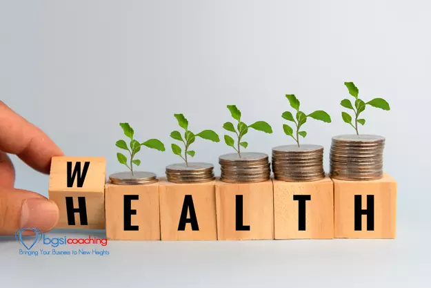 BGSICoaching | Hand holding wood cube block wealth and health with coin and tree on table.Business finance saving money wealth insurance and health care